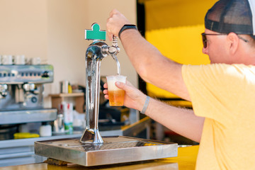 Man pouring fresh beer in self service bar - with all inclusive badge