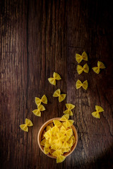 Farfale pasta on wood background,wood bowl,rustick backround.