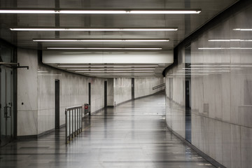 White-gray room. Illumination in a long corridor. Light walls and floor. Luster. Background.
