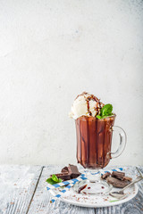 Iced chocolate cocktail. Cold summer sweet drink with cocoa, vanilla ice cream ball and mint leaves. wooden background copy space