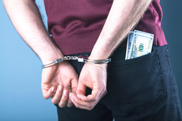 handcuffed man; prisoner, bribe