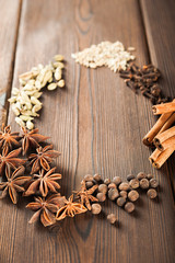 Seasoning on a textured wooden background close-up and copy space. Cinnamon, star anise, fennel, peppercorns, cloves, tea masala seasoning as a texture