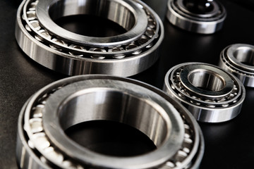 Full frame industrial background - metal bearings in close-up on a black background.