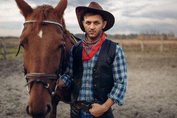 Cowboy poses with horse on texas farm