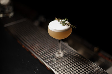 Delicious cocktail in the glass decorated with a smoked herb