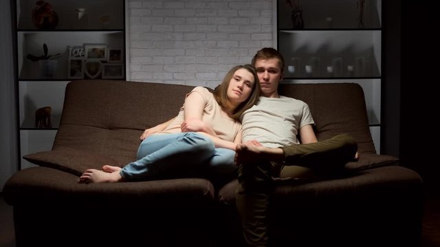 loving couple is sitting on the couch and watching TV.