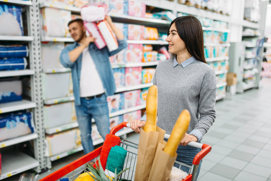 Couple Buying A Lot Of Diapers In Supermarket