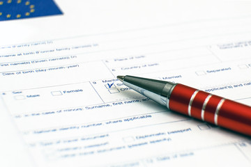 Schengen visa, questionnaire. Hand with pen completing a questionary.