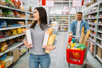 Couple with cart in supermarket, drinks department