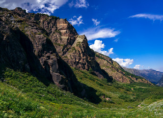 Fototapeta na wymiar Large panorama Massive Caucasian mountains in the surroundings of dombai in the clouds. Summer day.