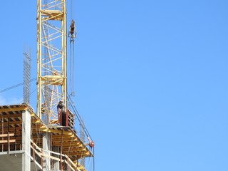 Aerial photograph of an unrecognized civil engineer without a face, watching the work of roof builders on the construction site. The concept of building with copy space.