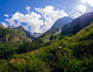Large panorama Massive Caucasian mountains in the surroundings of dombai in the clouds. Summer day.
