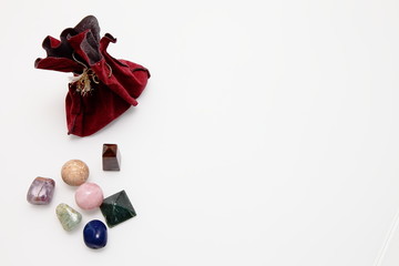 Magical stones and crystal of different shapes and colors lying in bulk on a white background.