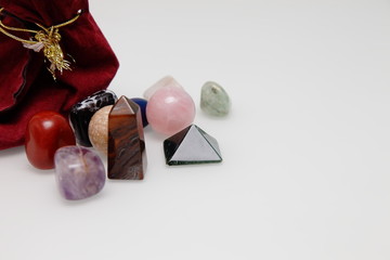 Magical stones and crystal of different shapes and colors lying in bulk on a white background.