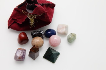 Magical stones and crystal of different shapes and colors lying in bulk on a white background.