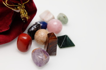 Magical stones and crystal of different shapes and colors lying in bulk on a white background.