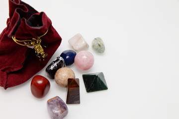 Magical stones and crystal of different shapes and colors lying in bulk on a white background.