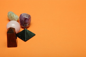 Magical stones and crystals of various shapes and colors lying loose on a yellow background