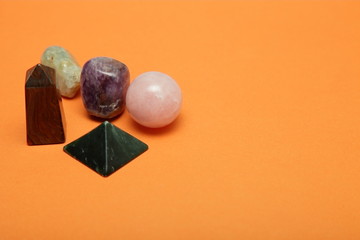 Magical stones and crystals of various shapes and colors lying loose on a yellow background