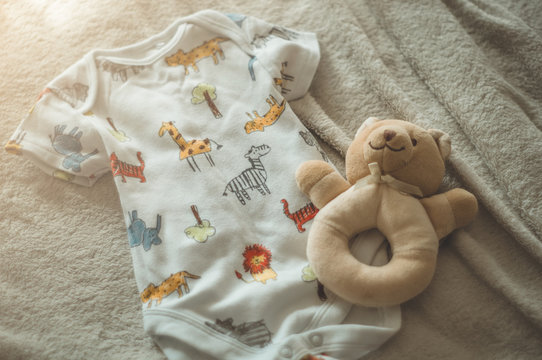 Little hand made baby clothes. Photo of ultrasound. newborn clothes on beige woolen background