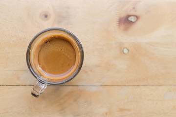 Top view of fresh coffee espresso in a coffee cup on wooden table in the cafe, image with copy space.