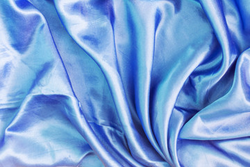 The texture of the dark blue silk fabric is folded. Empty abstract background for layouts.