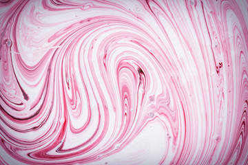 Empty abstract background for layouts. The process of mixing pink and white paint close-up. Photo with vignette.
