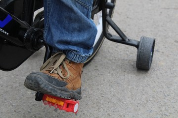 Obraz premium Children's bicycle with extra wheels, close-up.