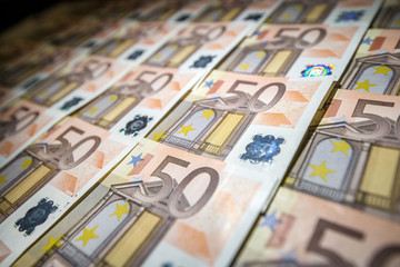 50 euro paper money on black background. Hundreds of banknotes. Concept of cash flow, finances, rich people, millionaire and successful business. 