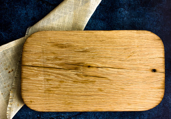 Cooking wooden table with cutting board over kitchen towel . Top view with space for your meal or recipe