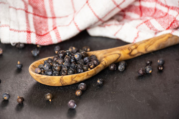 Lot of whole dry juniper berry seed on grey stone