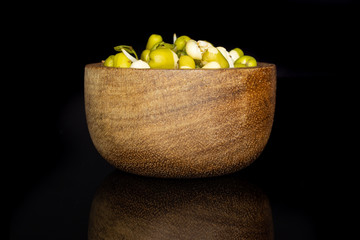 Lot of whole fresh green bean sprouts mungo with wooden bowl isolated on black glass