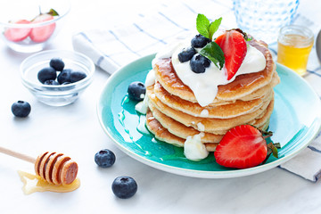 Stack of pancakes on the plate. Morning breakfast with berries on the table. Close up - obrazy, fototapety, plakaty