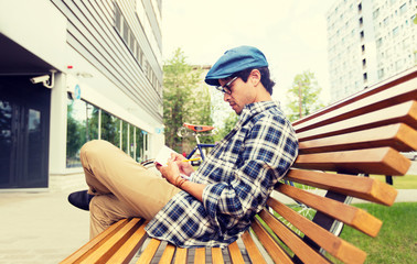 lifestyle, creativity, freelance, inspiration and people concept - creative man with notebook or diary writing sitting on city street bench