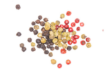 Lot of whole peppercorns of four colors flatlay isolated on white background