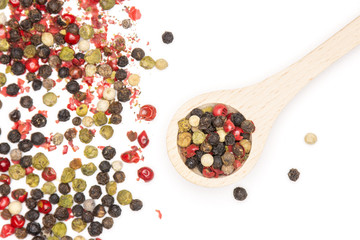 Lot of whole peppercorns of four colors with wooden spoon flatlay isolated on white background