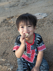 The boy is eating a crispy snack happily.