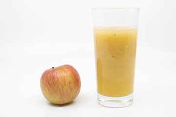 Glass of homemade apple juice with a red apple