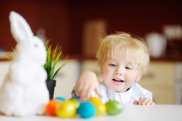 Fototapeta na wymiar Cute toddler child hunting for easter egg on Easter day