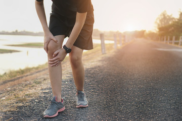 Runners leg pain, man holding sore and over trained painful leg muscle or cramp .Injured over...