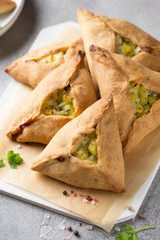 Tatar pie triangle echpochmak, Russian kurnik, delicious pastry with chicken and potatoes. Traditional food, quick snack of dough © maria_lapina