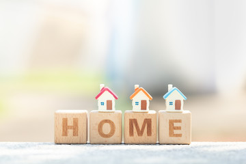 Three miniature house model on wooden block text dream. Business, finance, and saving money for dream house concept