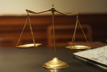 Gold brass balance scale,weight balance, imbalance scale on wooden desks with black background. Sign of justice, lawyer .