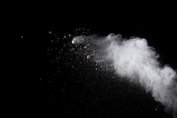 Abstract white powder explosion against black background.White dust exhale in the air.