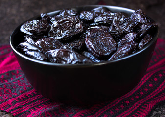 Dried prunes on plate. Top view of peeled plums. Top view.