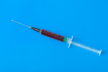 Medical syringe on blue
