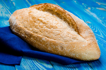 Whole loaf bread with crisp on wooden background top view