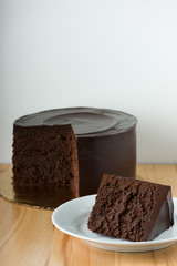 Slice Of Chocolate Cake On Wooden Table With White Background And Copy Space