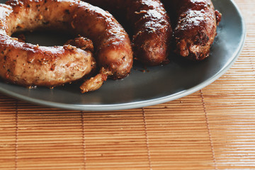 delicious juicy grilled sausages on a plate on the table