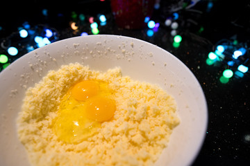 Cracking egg over bowl. Woman is cooking in kitchen, baking a cake or pastry products. Raw, uncooked dough made of flour, eggs, sugar and butter. Delicious, homemade dessert